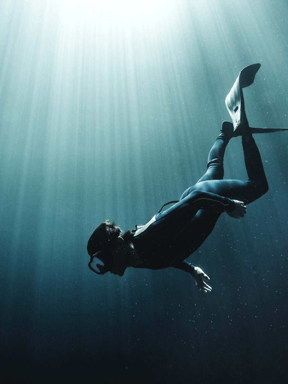 underwater-view-of-diver-wearing-wet-suit-and-flippers-sunlight-filtering-through-from-above-.jpg